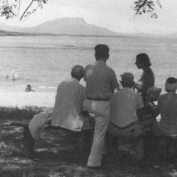 A group of people gather by the beach A group of people gather by the beach